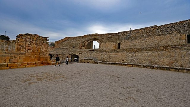 Blick aus dem Inneren der Arena auf die mächtigen Zuschauerränge und ein erhaltenes Torbogen-Vomitorium nz7 0762