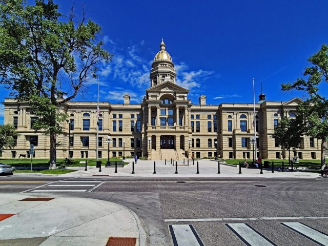 Die weitläufige, vollkommen symmetrische Hauptfassade des Wyoming State Capitol in einer zentralen Frontalansicht vom Vorplatz aus. 1013