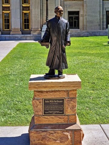 Die lebensgroße Bronzestatue des berühmten Richters Willis Van Devanter in seiner fließenden Robe auf einem gemauerten Natursteinsockel vor dem Gerichtsgebäude. 1020
