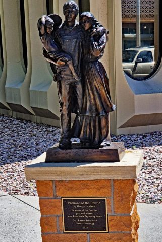 Das Siedler-Denkmal „Promise of the Prairie“ - die ausdrucksstarke Bronzeskulptur einer Siedlerfamilie auf einem Steinsockel, die Schutz und Zusammenhalt der frühen Pioniere symbolisiert. 1021